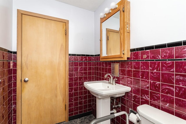 bathroom featuring tile walls and toilet