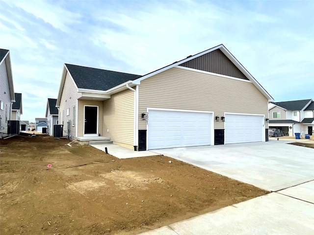 view of side of property featuring central AC unit and a garage