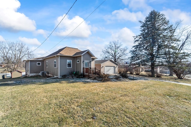 view of side of property featuring a lawn, central air condition unit, and a garage