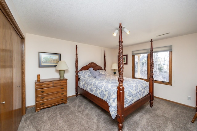 bedroom with a textured ceiling, a closet, and carpet