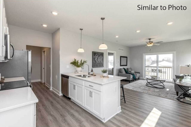 kitchen featuring white cabinets, stainless steel appliances, ceiling fan, sink, and decorative light fixtures