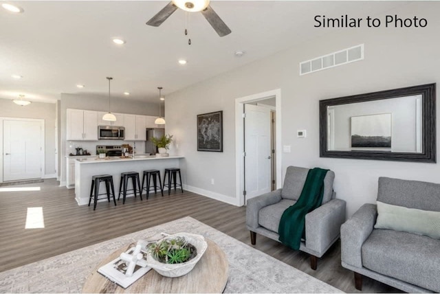 living room featuring dark wood-type flooring and ceiling fan