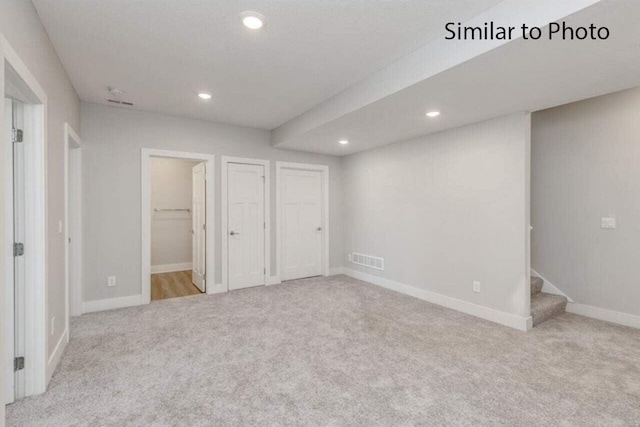 unfurnished bedroom featuring ensuite bathroom and light colored carpet