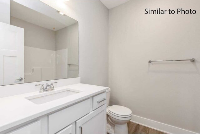 bathroom featuring toilet, a shower, vanity, and hardwood / wood-style floors