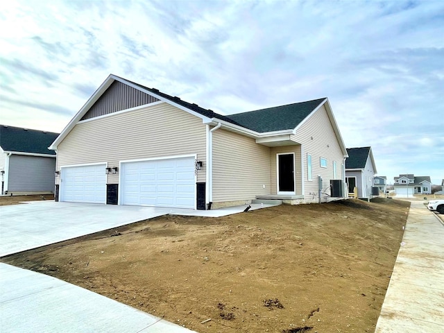 view of front of home with a garage and central AC unit