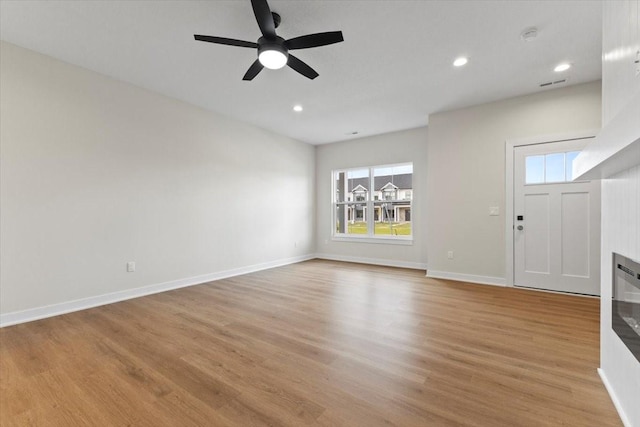 1991 S Warrior Ln, Waukee, IA 50263 - unfurnished living room featuring ceiling fan, light wood-type flooring, baseboards, and recessed lighting