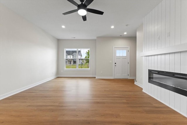 1991 S Warrior Ln, Waukee, IA 50263 - unfurnished living room featuring ceiling fan, a fireplace, wood finished floors, recessed lighting, and baseboards