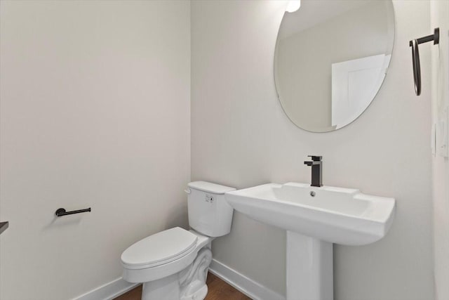 1991 S Warrior Ln, Waukee, IA 50263 - half bathroom featuring baseboards, toilet, and wood finished floors