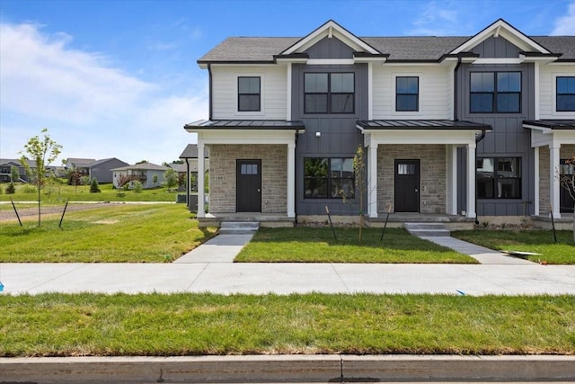 1991 S Warrior Ln, Waukee, IA 50263 - view of property featuring a standing seam roof, stone siding, and a front lawn