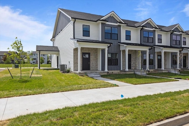 1991 S Warrior Ln, Waukee, IA 50263 - multi unit property featuring board and batten siding, stone siding, a front lawn, and central AC unit