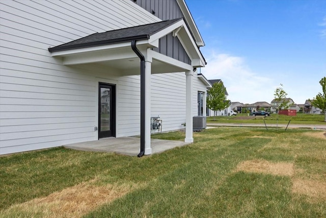 1991 S Warrior Ln, Waukee, IA 50263 - view of side of property with board and batten siding, a lawn, central air condition unit, and a patio area
