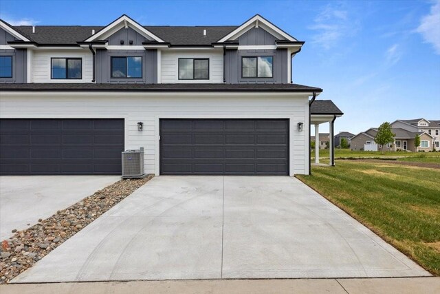 1991 S Warrior Ln, Waukee, IA 50263 - view of front of house with concrete driveway, a front yard, board and batten siding, and a garage