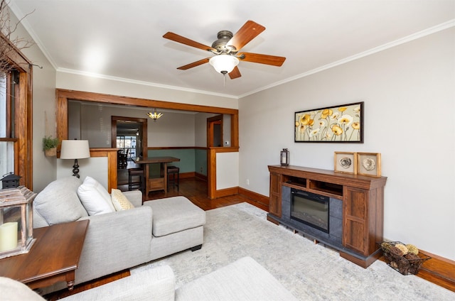 living room with crown molding, ceiling fan with notable chandelier, and hardwood / wood-style flooring