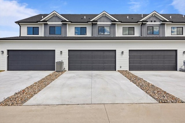 1995 S Warrior Ln, Waukee, IA 50263 - townhome / multi-family property featuring a garage, driveway, central AC, and board and batten siding