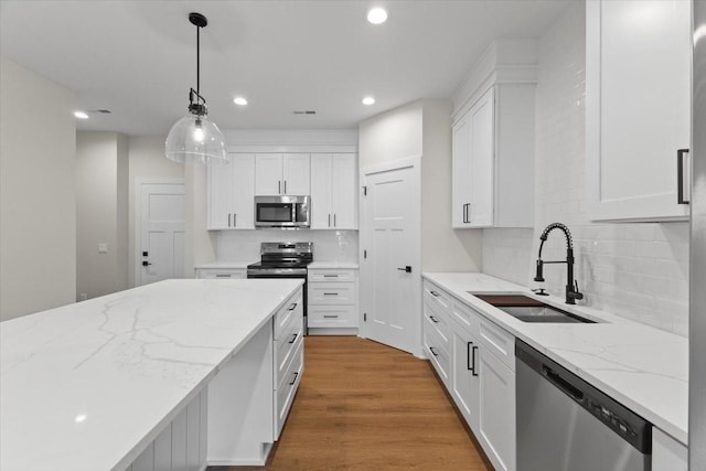 1995 S Warrior Ln, Waukee, IA 50263 - kitchen with stainless steel appliances, a sink, white cabinets, backsplash, and recessed lighting