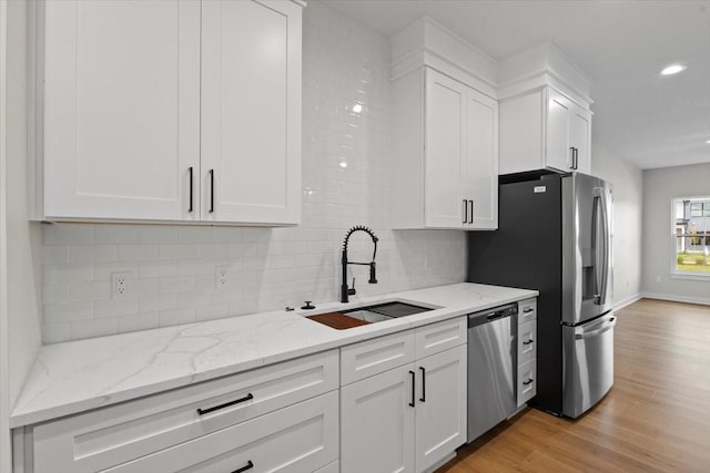 1995 S Warrior Ln, Waukee, IA 50263 - kitchen with a sink, stainless steel appliances, white cabinets, decorative backsplash, and recessed lighting