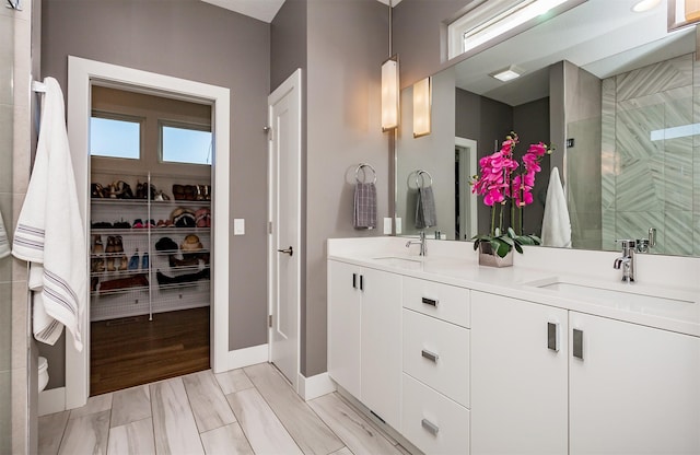 bathroom with vanity and a shower with door