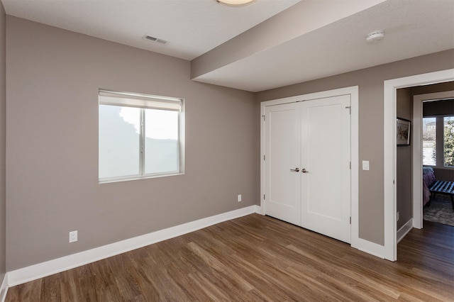 unfurnished bedroom featuring hardwood / wood-style floors and a closet