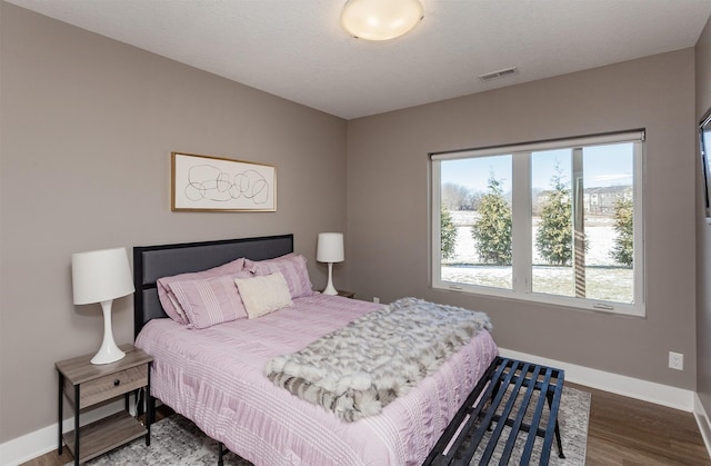 bedroom featuring hardwood / wood-style flooring and a textured ceiling