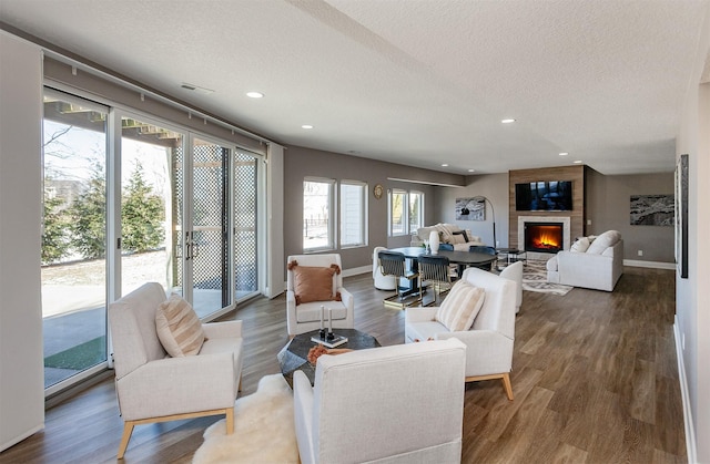 living room featuring dark hardwood / wood-style flooring, a fireplace, and a textured ceiling