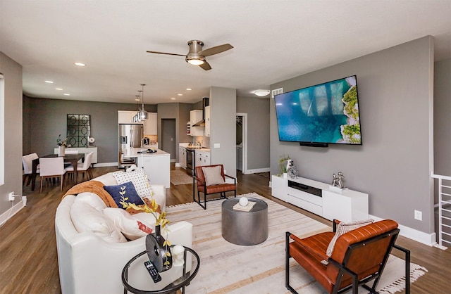 living room with ceiling fan, sink, and light hardwood / wood-style floors