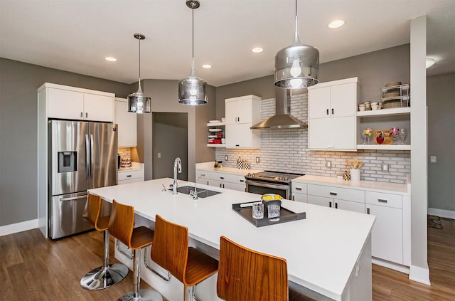 kitchen with sink, white cabinets, decorative backsplash, a kitchen island with sink, and stainless steel appliances