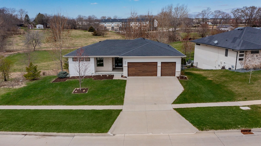 ranch-style house with a residential view, driveway, a front yard, and a garage