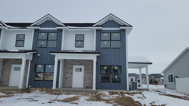 modern inspired farmhouse featuring stone siding and board and batten siding