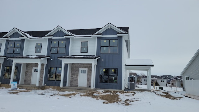 view of front of house featuring a standing seam roof, stone siding, board and batten siding, and metal roof