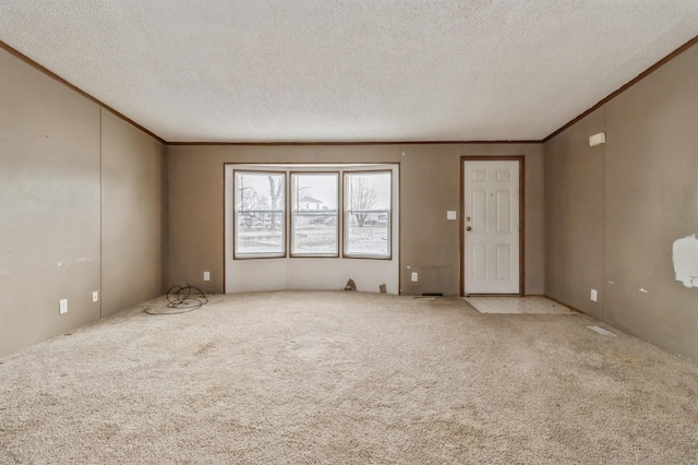 carpeted empty room featuring a textured ceiling