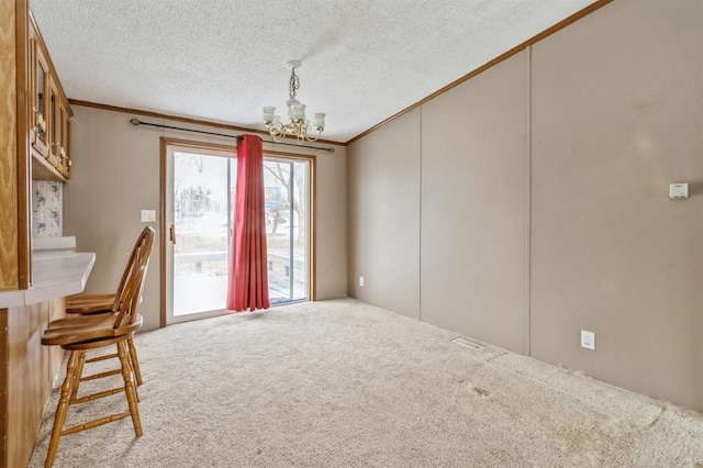 interior space with an inviting chandelier, ornamental molding, and a textured ceiling