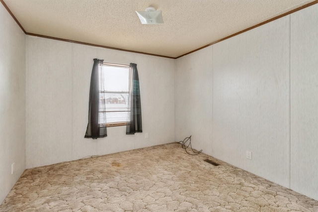 spare room with a textured ceiling and carpet flooring