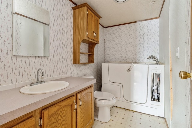 bathroom with toilet, a bathing tub, crown molding, washer / clothes dryer, and vanity