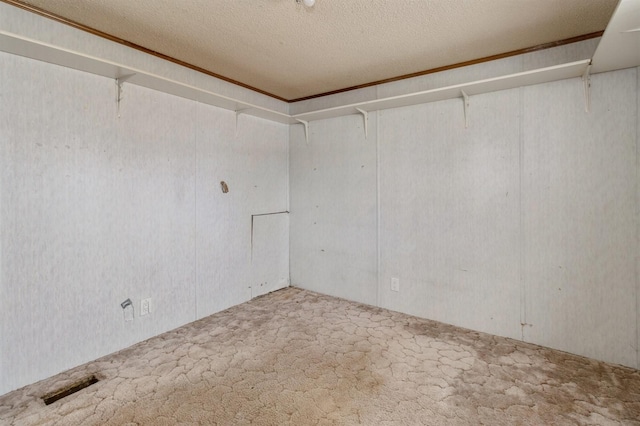 spare room with a textured ceiling and carpet