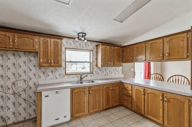 kitchen with kitchen peninsula, a textured ceiling, dishwasher, and sink