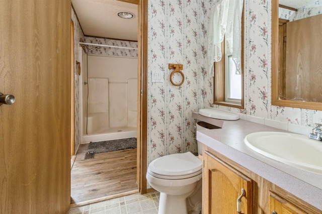 bathroom featuring toilet, a shower, vanity, and hardwood / wood-style floors