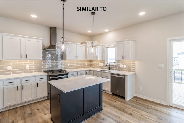 kitchen with wall chimney range hood, a center island, white cabinetry, hanging light fixtures, and appliances with stainless steel finishes