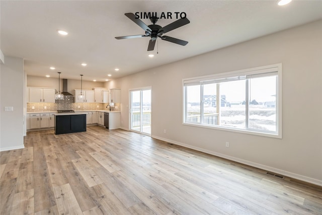 unfurnished living room with ceiling fan and light hardwood / wood-style flooring