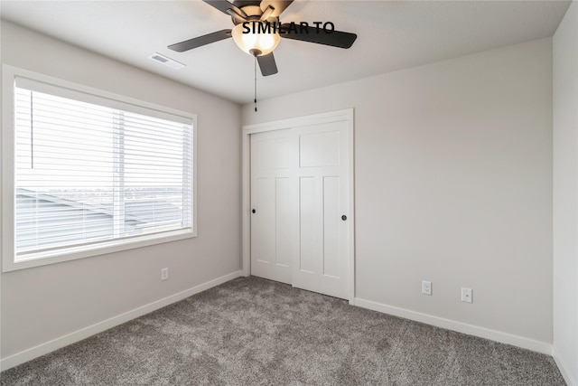 unfurnished bedroom featuring ceiling fan, a closet, and carpet flooring