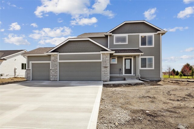 546 34th St SE, Altoona, IA 50009 - view of front of property featuring driveway, a garage, stone siding, and a shingled roof