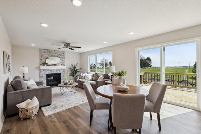 546 34th St SE, Altoona, IA 50009 - dining space with wood finished floors, ceiling fan, a fireplace, and recessed lighting