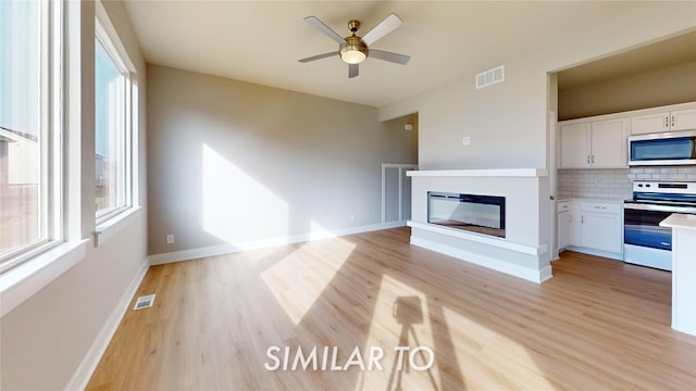 unfurnished living room with ceiling fan and light hardwood / wood-style floors