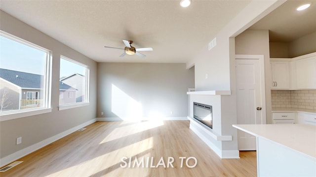 unfurnished living room featuring ceiling fan and light hardwood / wood-style floors