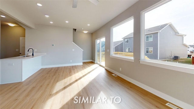 unfurnished living room featuring light hardwood / wood-style floors and sink