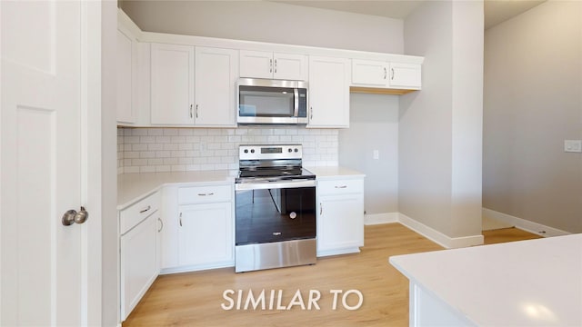 kitchen featuring appliances with stainless steel finishes, backsplash, and white cabinetry