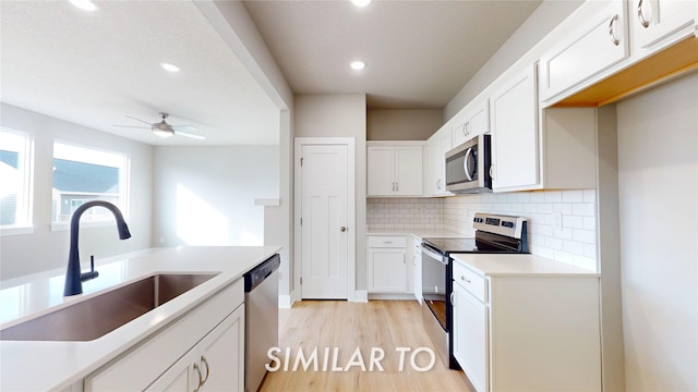 kitchen featuring sink, decorative backsplash, white cabinetry, and appliances with stainless steel finishes