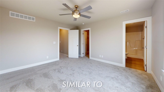 unfurnished bedroom with ensuite bathroom, light carpet, ceiling fan, and a walk in closet