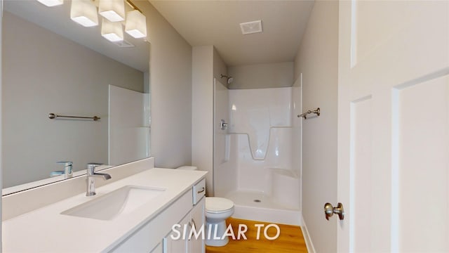 bathroom featuring toilet, walk in shower, vanity, and hardwood / wood-style flooring