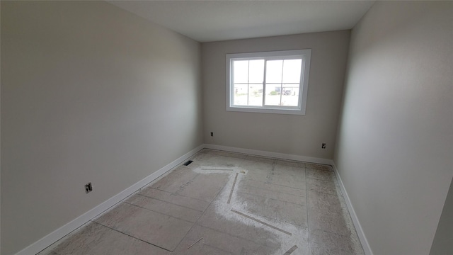 unfurnished room with baseboards