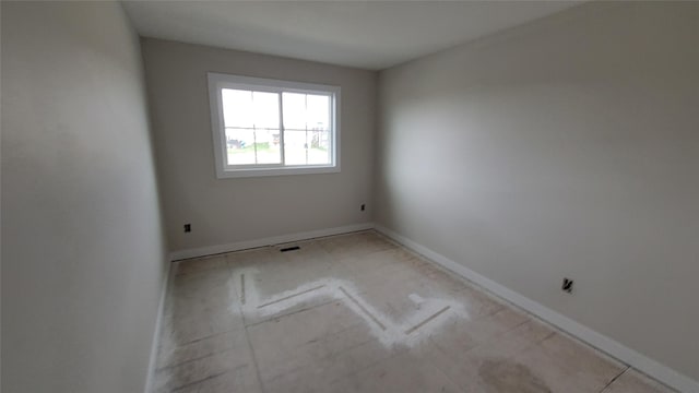 unfurnished room with baseboards